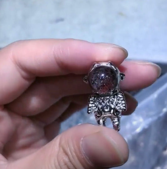 Garden quartz astronaut pendant showing green chlorite and iron oxide inclusions inside clear quartz