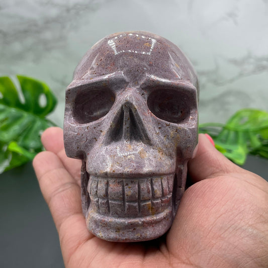 Pink ocean jasper skull carving showing orbicular patterning, from Madagascar material