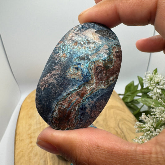Natural chrysocolla palm stone showing swirled blue-green copper mineral coloring