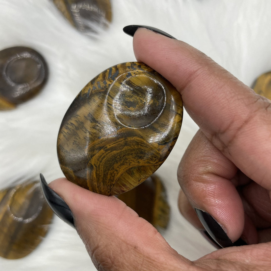 Tiger eye thumbprint worry stones showing golden chatoyant banding